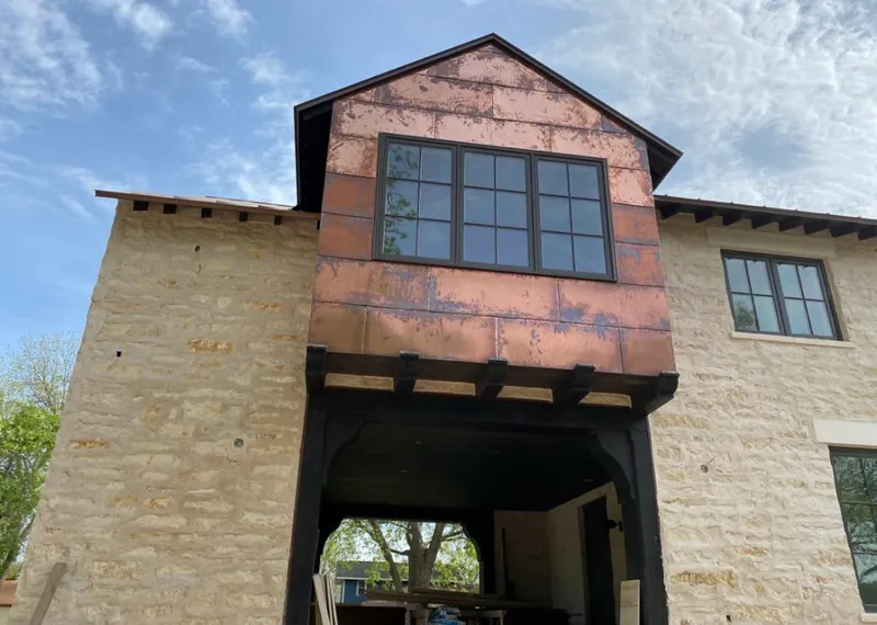 Copper metal panel facade on a stone building for Skylight Installation in Eldridge